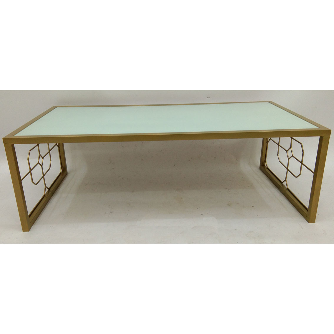 Gold rectangular metal coffee table with white glass top and geometric metal side decor